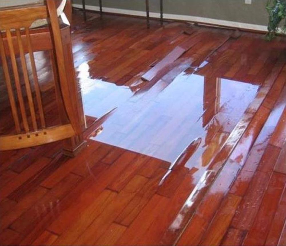 Standing water over a damaged wood floor.