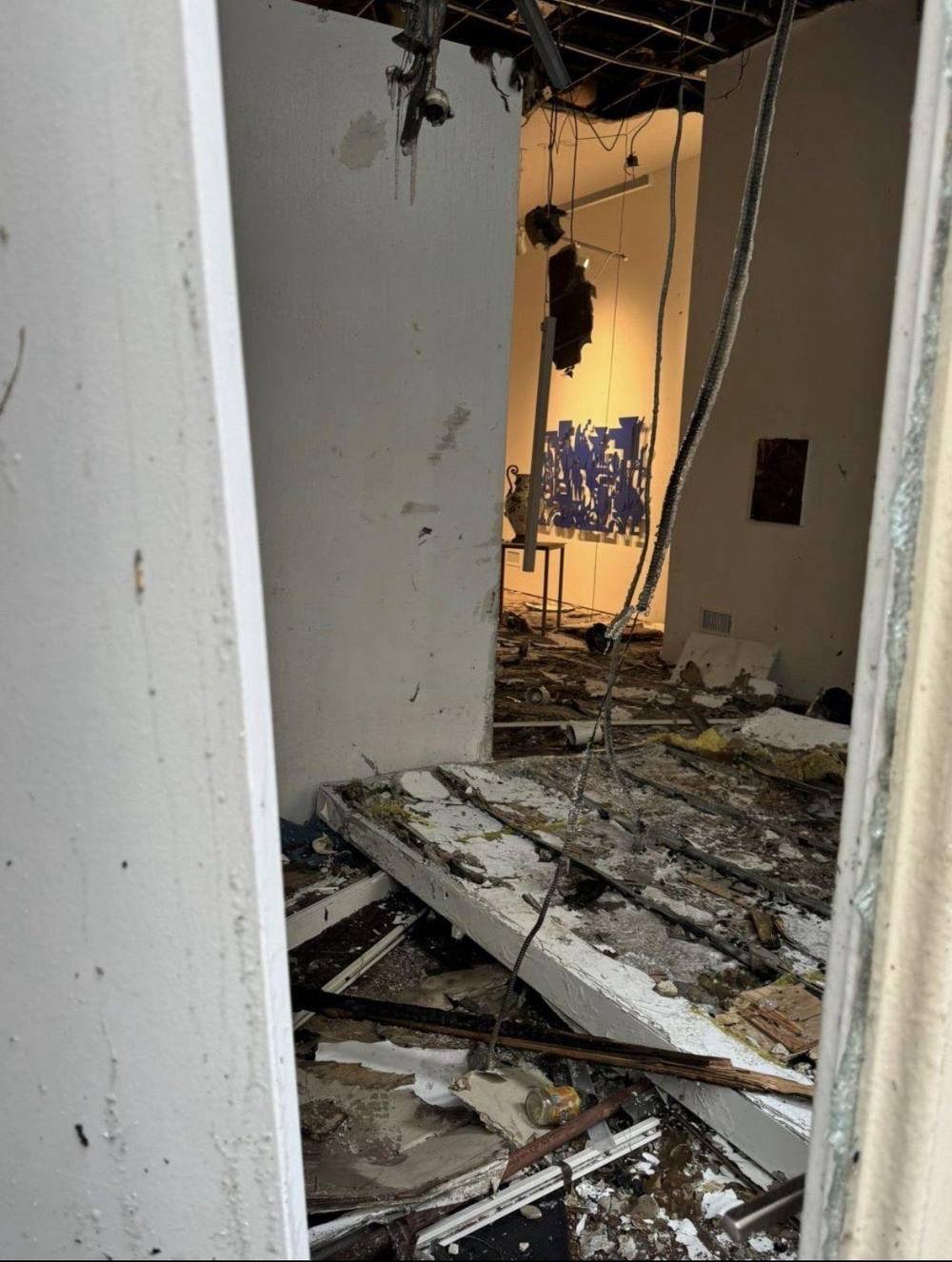 Fire-damaged interior with collapsed ceiling and debris.
